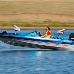 Man driving a fast boat with panned (motion blur) background.